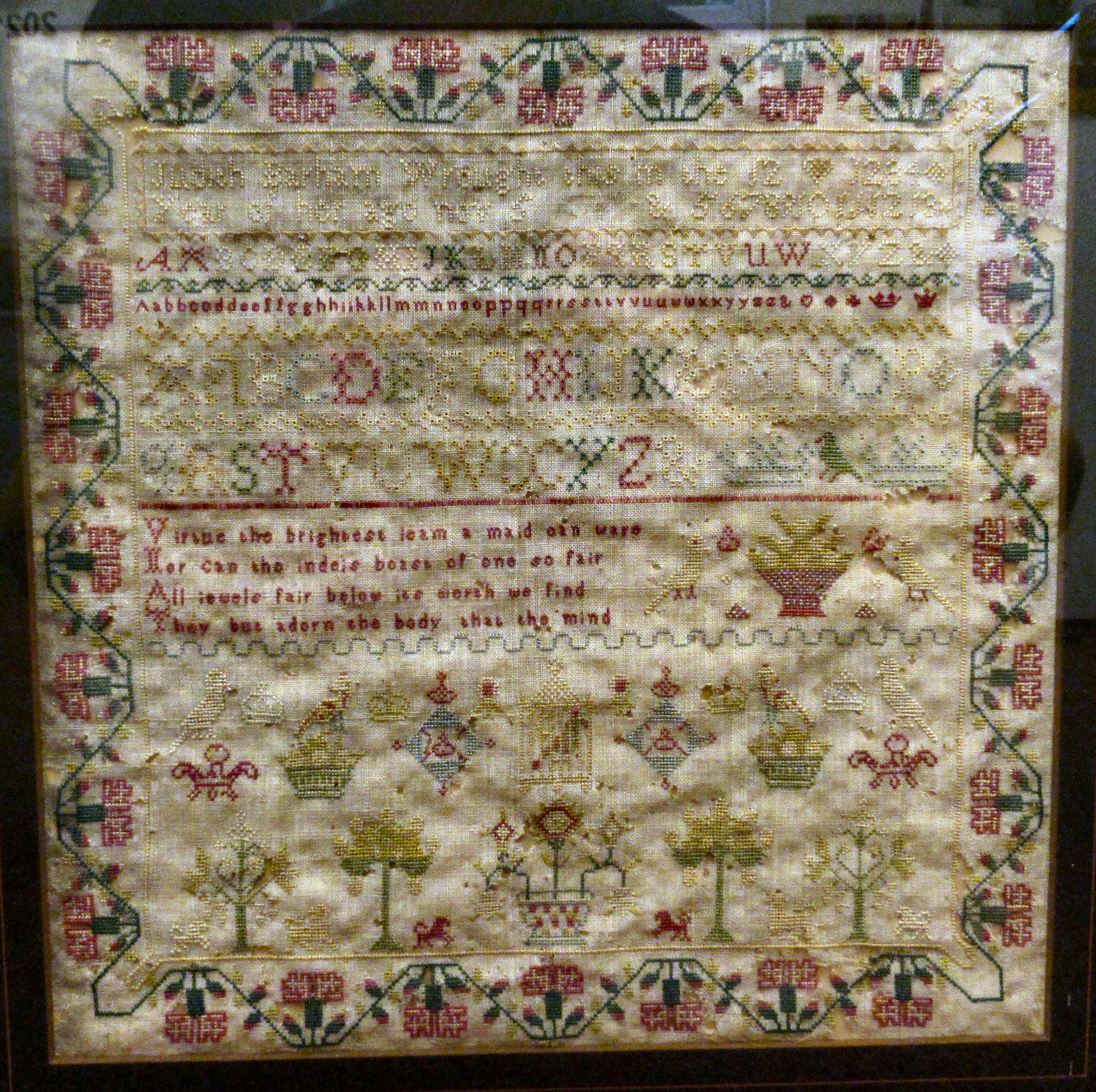 An early 19thC needlework sampler, the work of one Judith Barham, aged 12, featuring four lines of