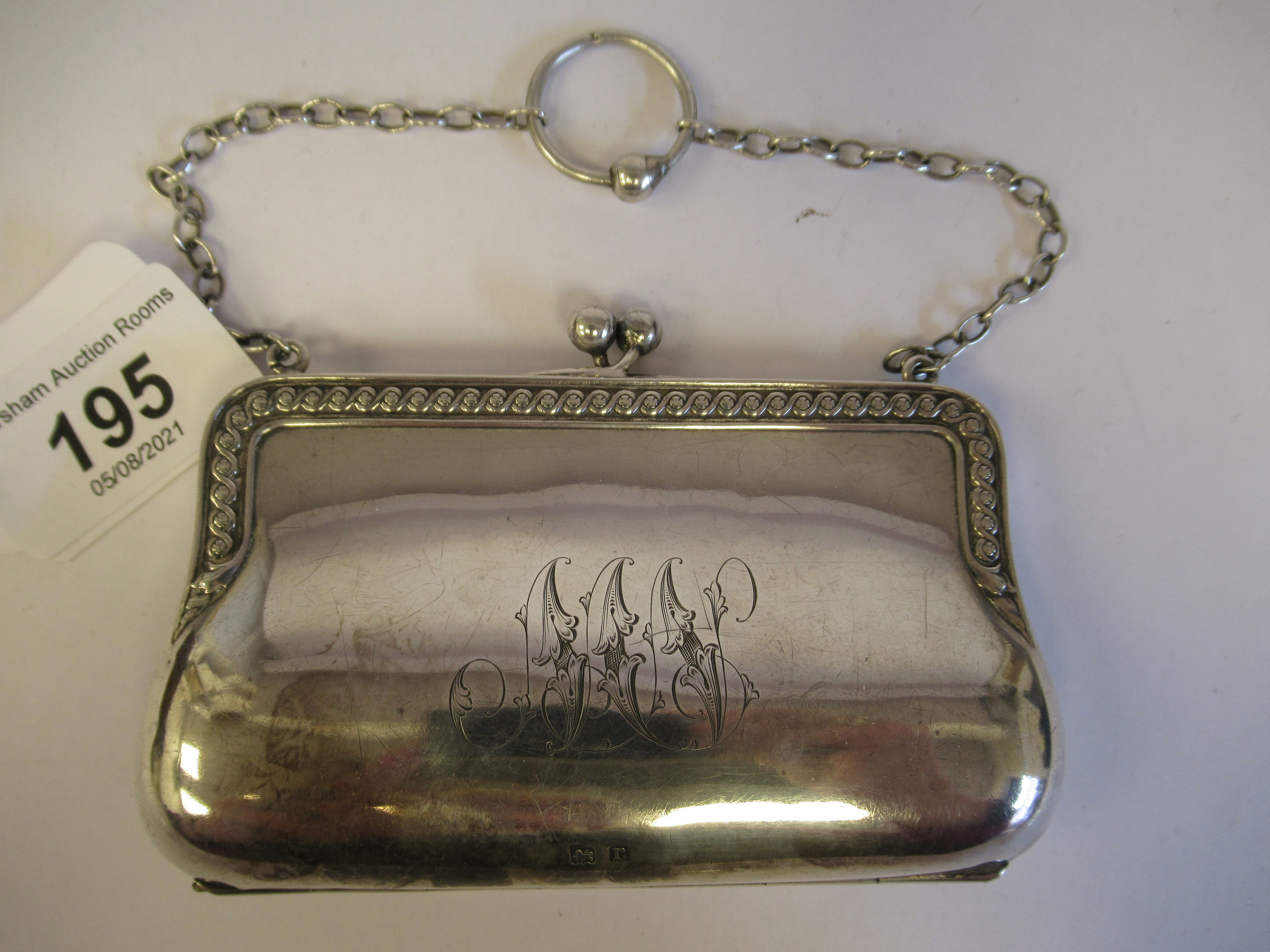 A silver purse, fashioned as a lady's handbag with a chain carrying handle and a cast vitruvian