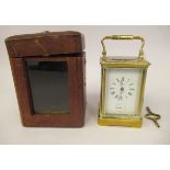 An early 20thC brass cased carriage clock with bevelled glass panels, a folding top handle, on a