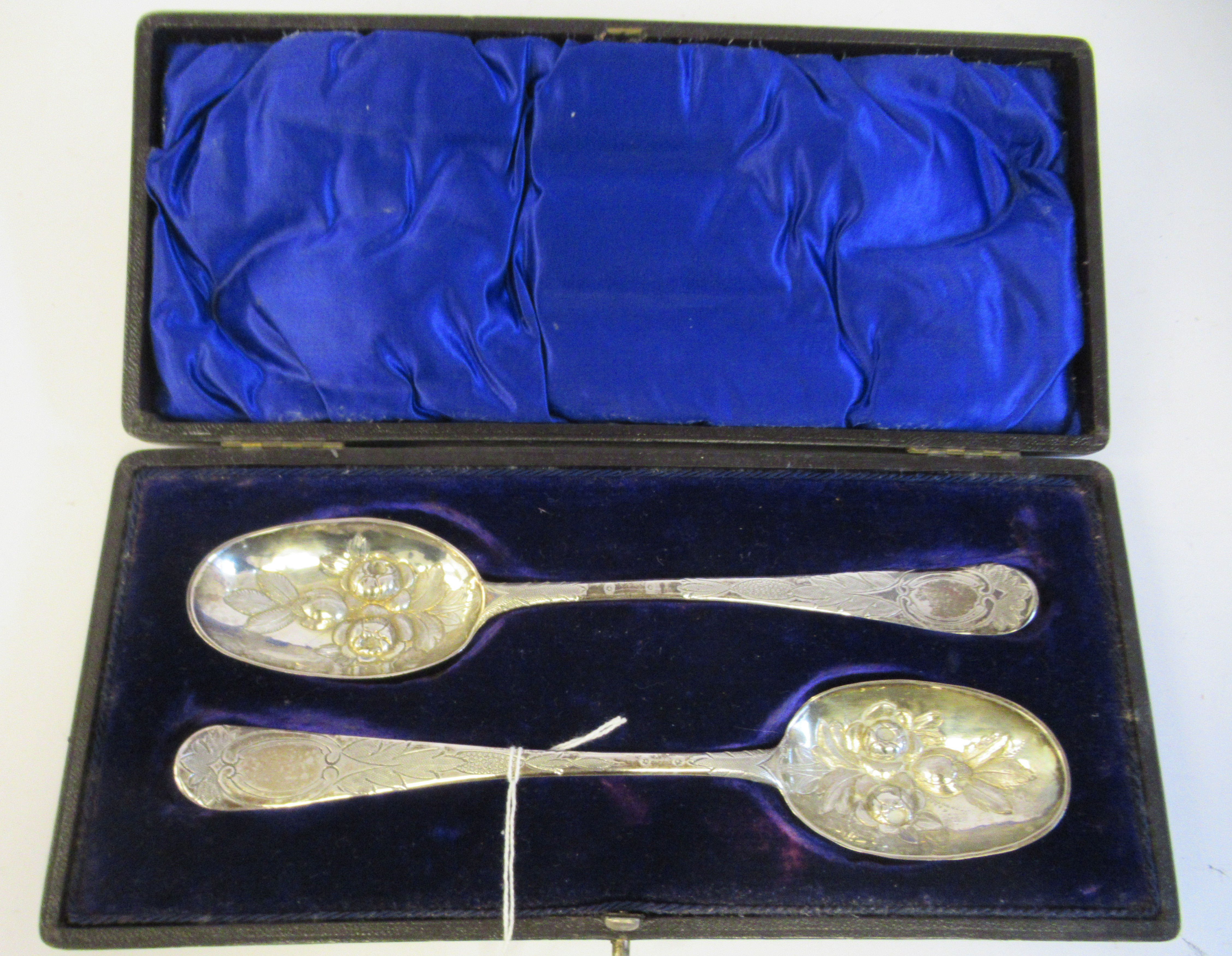 A pair of George III silver Old English pattern berry spoons with impressed, engraved and chased