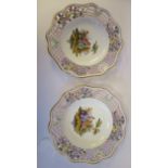 A pair of 20thC Meissen porcelain plates, each featuring a couple in a garden setting with a wide,