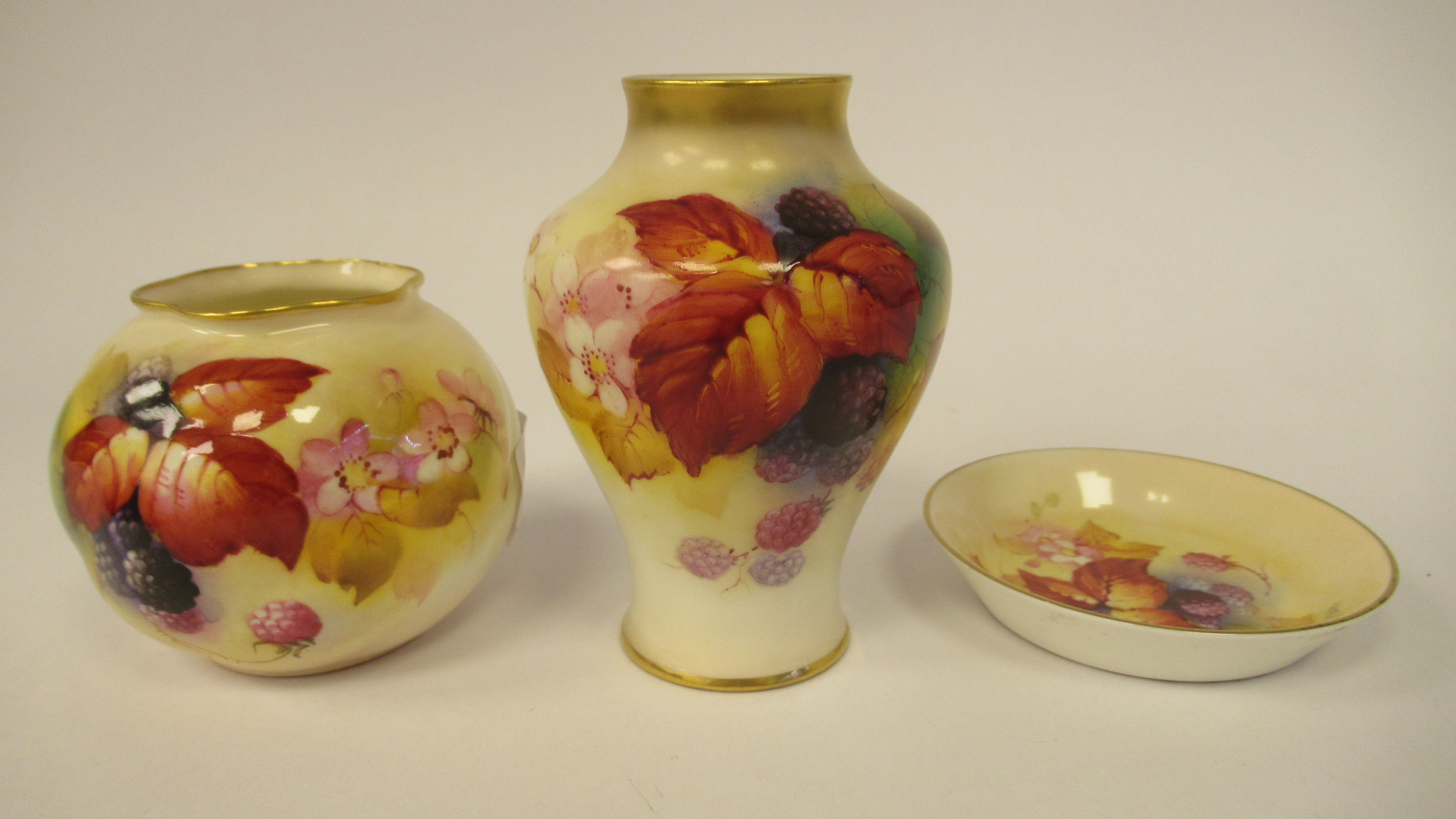 Three dissimilar pieces of Royal Worcester gilded, blush ivory glazed china, decorated by Kitty