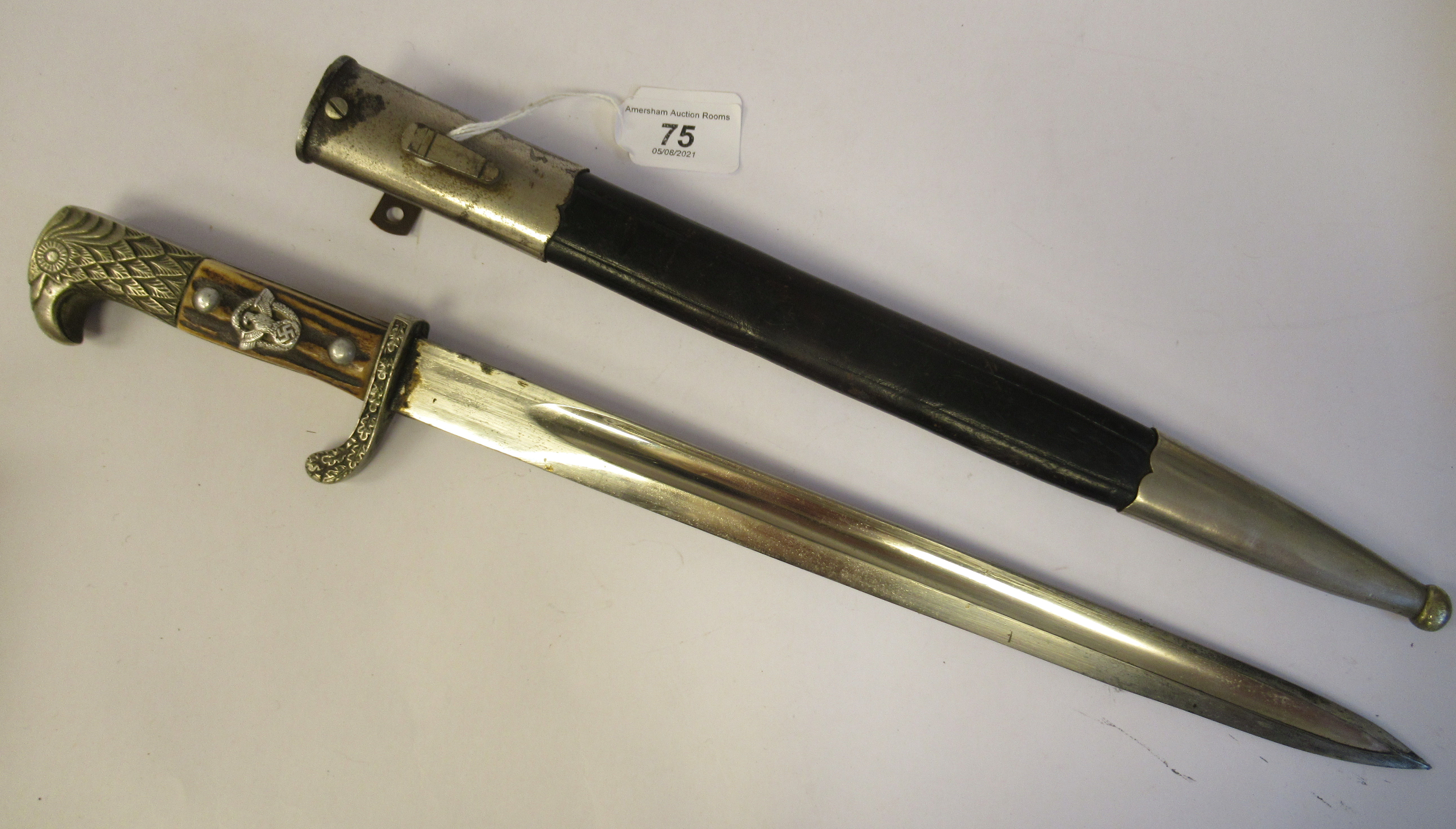 A German Third Reich police bayonet with an eagle's head pommel, over a rough-cut stag horn