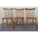 A set of three mid 20thC Ercol beech framed, spindled, level, curved back dining chairs, the solid