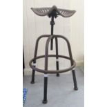 A modern patinated cast metal, tractor design stool with a rotating, height adjustable seat