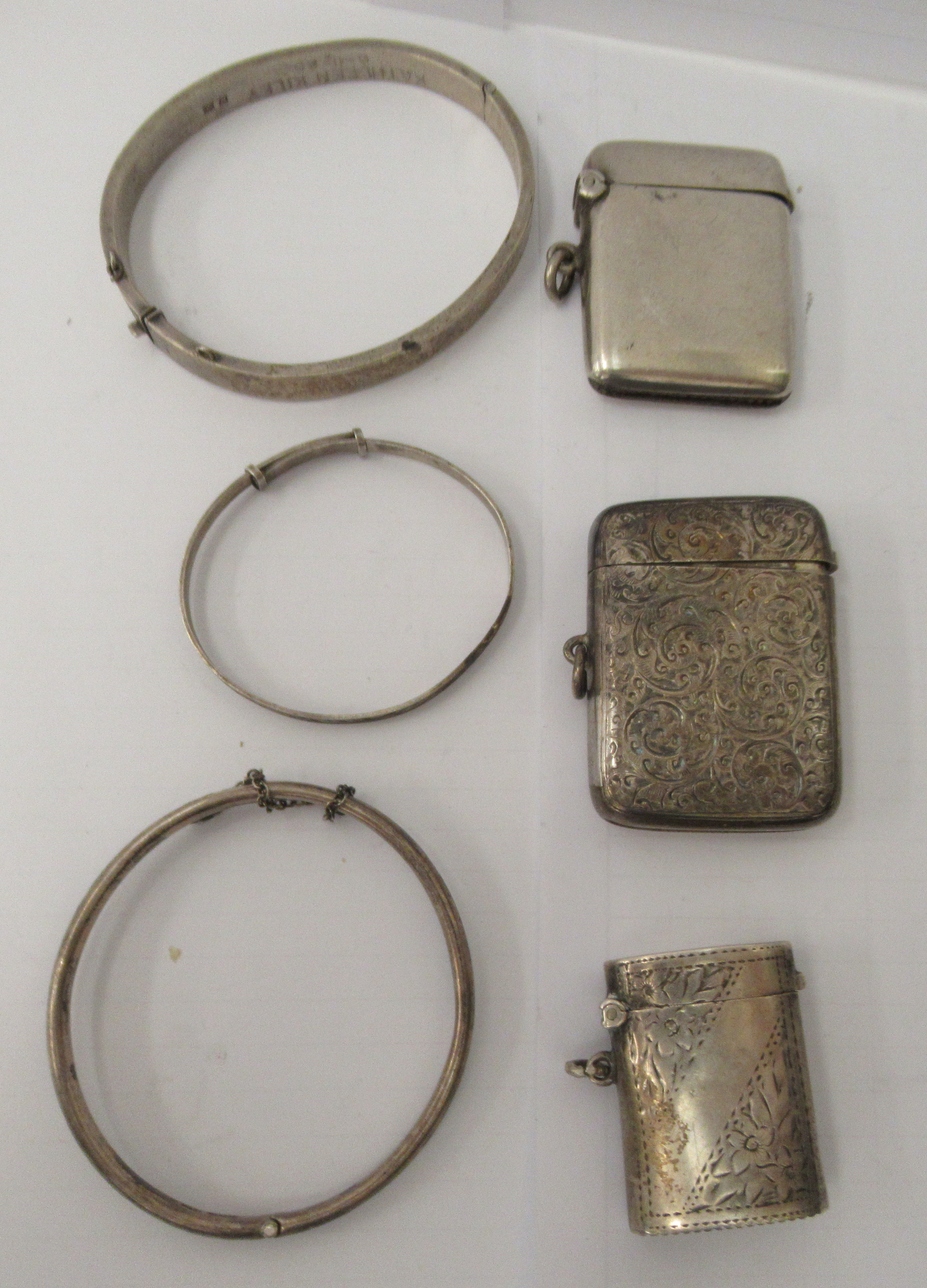 Three similar late 19th/early 20thC variously decorated silver vesta cases with strike plates,