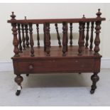 A late Victorian walnut Canterbury with three sections and pillar uprights, on a box drawer base,