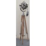 A modern chromium finished spotlight design lamp, on a stained beech height adjustable tripod