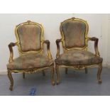 A pair of 20thC Louis XV inspired, giltwood framed and carved, open arm salon chairs, stud