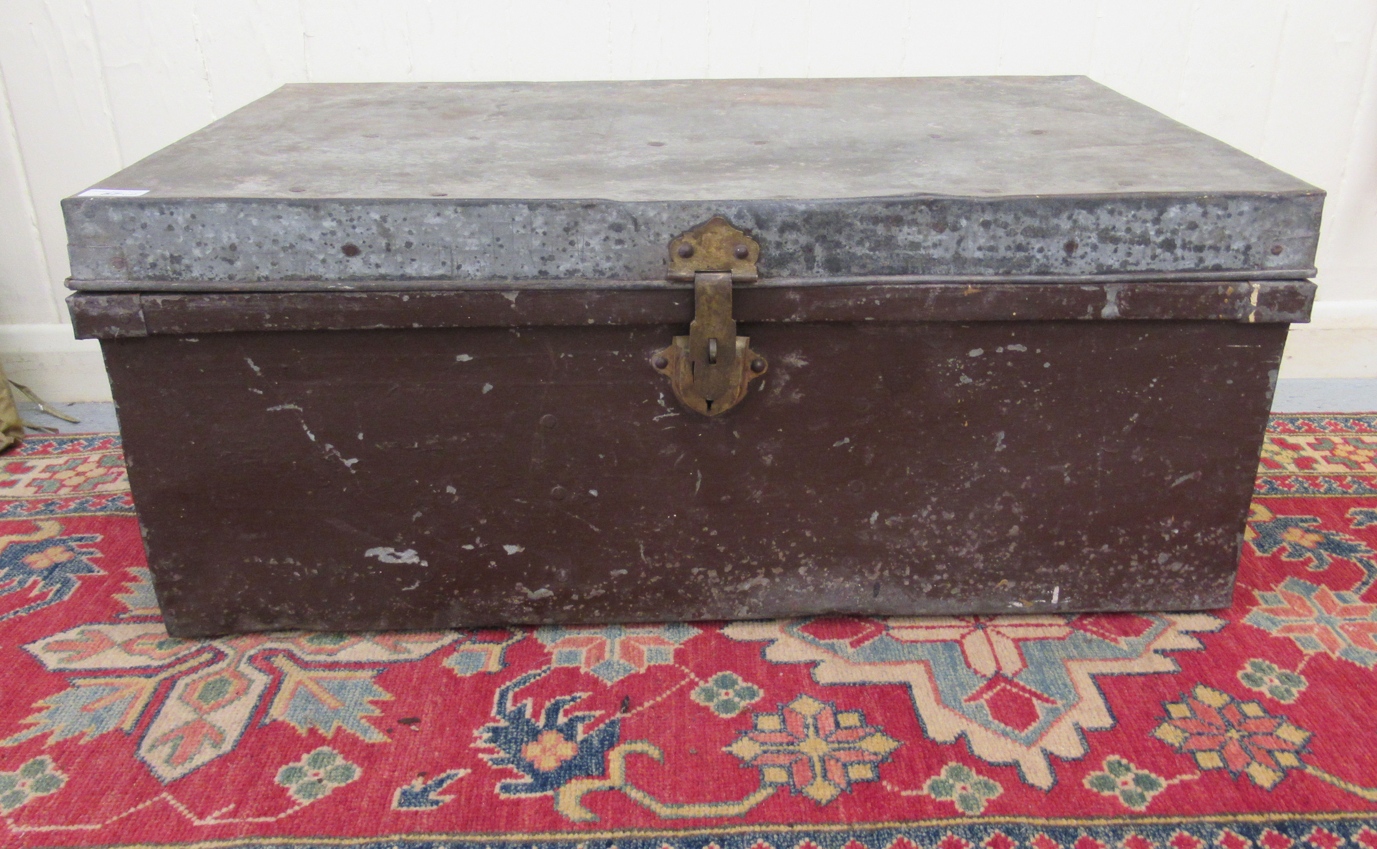 An early/mid 20thC steel trunk with straight sides and a hinged lid  12"h  26"w