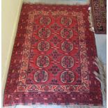 A Bokhara rug, decorated with two columns of five octagonal guls, on a red ground  45" x 56"