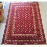 A Bokhara rug, decorated with four columns of twelve gulls, bordered by stylised designs, on a red