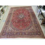 A Keshan carpet, profusely decorated with floral designs in bright colours, on a red ground  120"