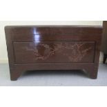 A mid 20thC Chinese carved camphorwood chest, having straight sides and a hinged lid, raised on