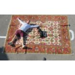 An Indian Agra carpet, decorated in bright colours with stylised floral designs, on a multi-coloured