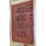 A Bokhara rug, decorated with elephant foot motifs, on a red and blue ground  69" x 42"