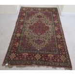 A Persian rug, decorated with a serpentine outlined medallion, bordered by stylised designs on a