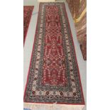 A Persian runner, decorated with floral motifs, on a red and blue ground  134" x 33"