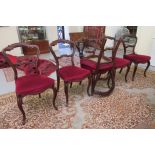 A set of six late Victorian walnut and other framed, floral carved, bar back dining chairs, the