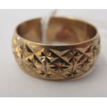A 9ct gold band ring with chiselled ornament