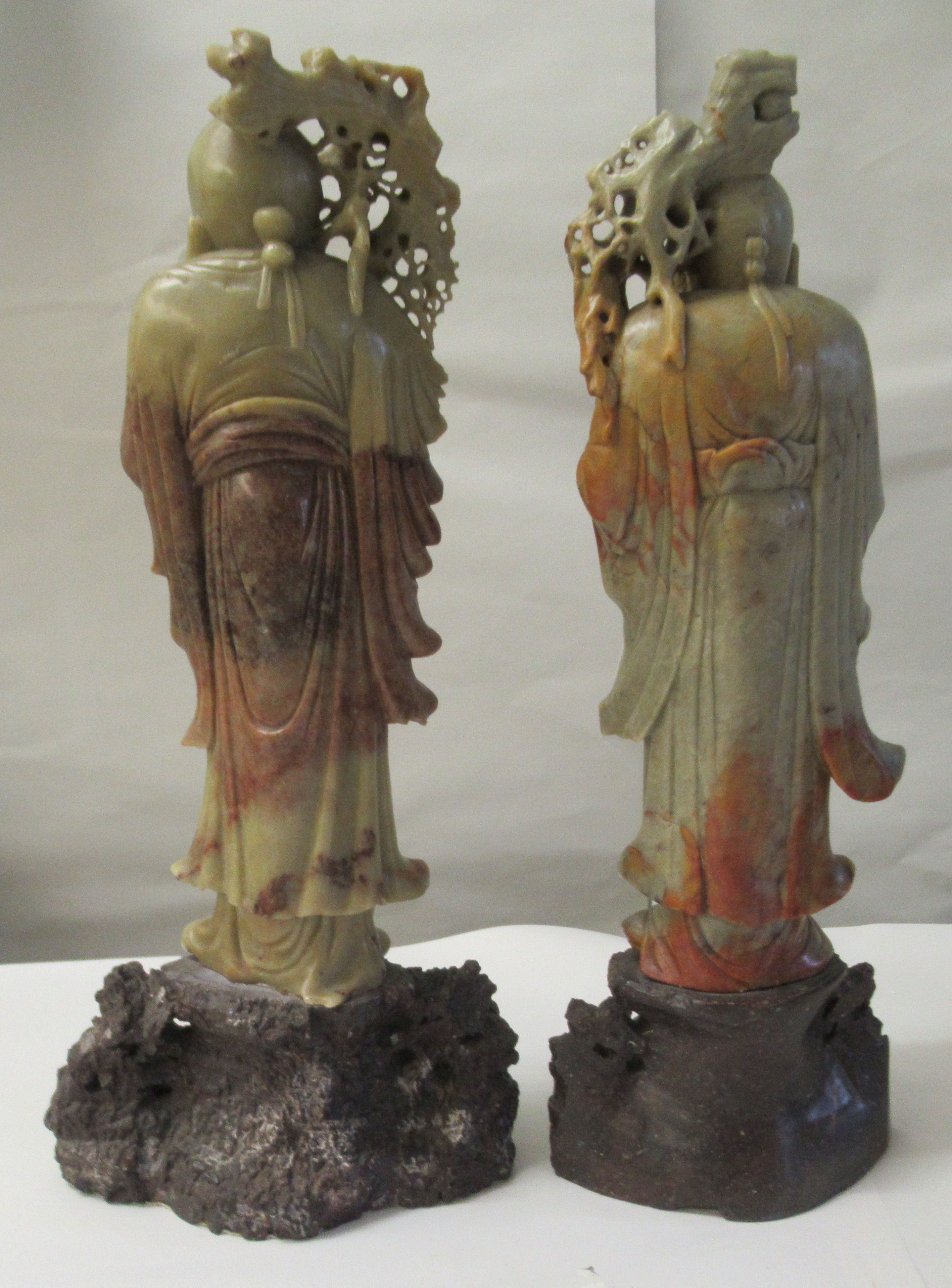 A matched pair of 20thC Chinese carved green and brown soapstone standing figures, each with a