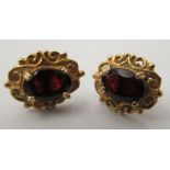 A pair of 9ct gold rings, claw set, garnets