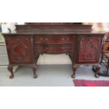 A 1920s mahogany serpentine front sideboard with two central drawers, flanked by two panelled doors,