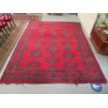 A Persian carpet, decorated with stylised designs, on a red ground  140" x 110"