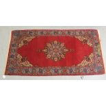 A Tabriz rug, decorated with a central medallion, bordered by floral designs, on a red ground  41" x