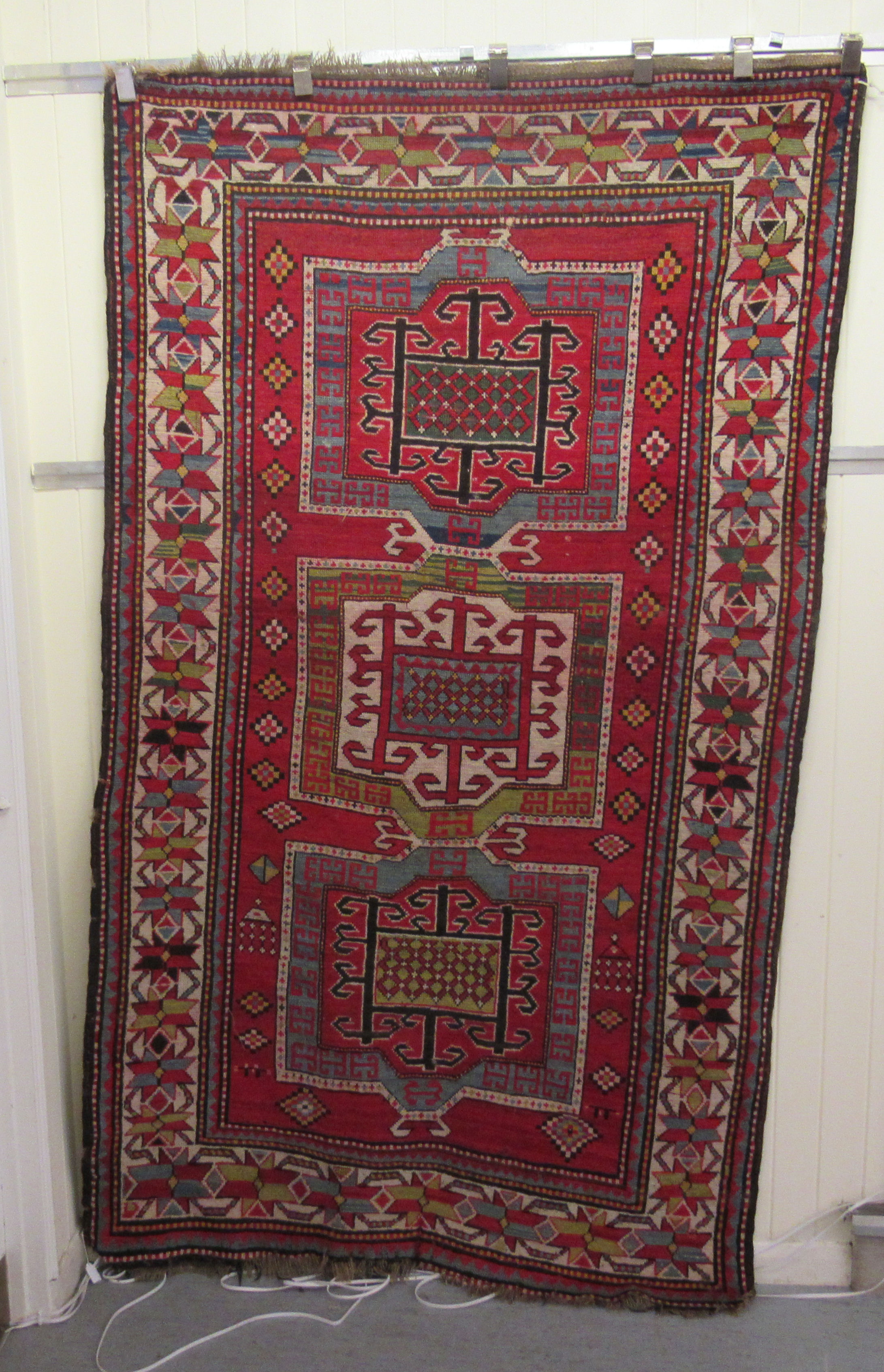 An Afghan Kazak rug, decorated with repeating geometric designs, on a cream ground  52" x 94"