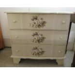 A modern white painted and floral stencilled three drawer dressing chest, raised on bracket feet