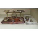 A set of brass postal scales, on a mahogany platform base with attendant weights