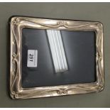 A glazed silver photograph frame in Art Nouveau taste, on a fabric back and easel stand