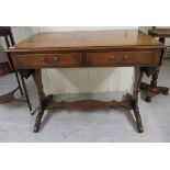 A 20thC walnut finished sofa table, the top with fall flaps, over two frieze drawers, raised on lyre