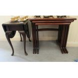 A modern nesting set of three mahogany finished occasional tables with crossbanded borders, raised