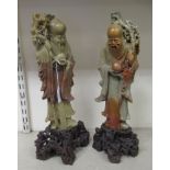 A matched pair of 20thC Chinese carved green and brown soapstone standing figures, each with a