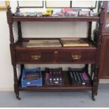 An Edwardian mahogany three tier buffet with a central deep drawer, raised on turned, fluted