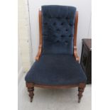 A late Victorian walnut framed salon chair with a button upholstered blue fabric back and seat,
