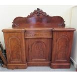 A late Victorian mahogany inverted breakfront sideboard, the top with a low upstand, over a