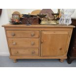 A late Victorian stained pine sideboard with an upstand, over three drawers and a panelled door,
