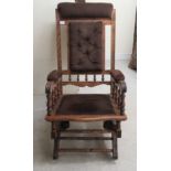 A late 19thC American design stained beech framed rocking chair