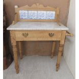A late Victorian stained pine washstand with a marble top and tiled upstand, over a drawer, raised