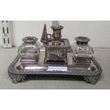 A mid 19thC Sheffield plate inkstand with a central candle sconce, flanked by two glass inkwells