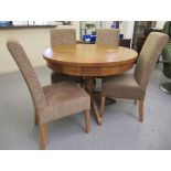 A modern light oak pedestal dining table  31"h  43"dia extending to 56"w with an integral leaf;
