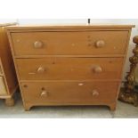 A late Victorian pine dressing chest, comprising three long drawers, raised on bracket feet  31"h