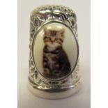 A silver coloured metal and enamel thimble, featuring a plaque, depicting a kitten