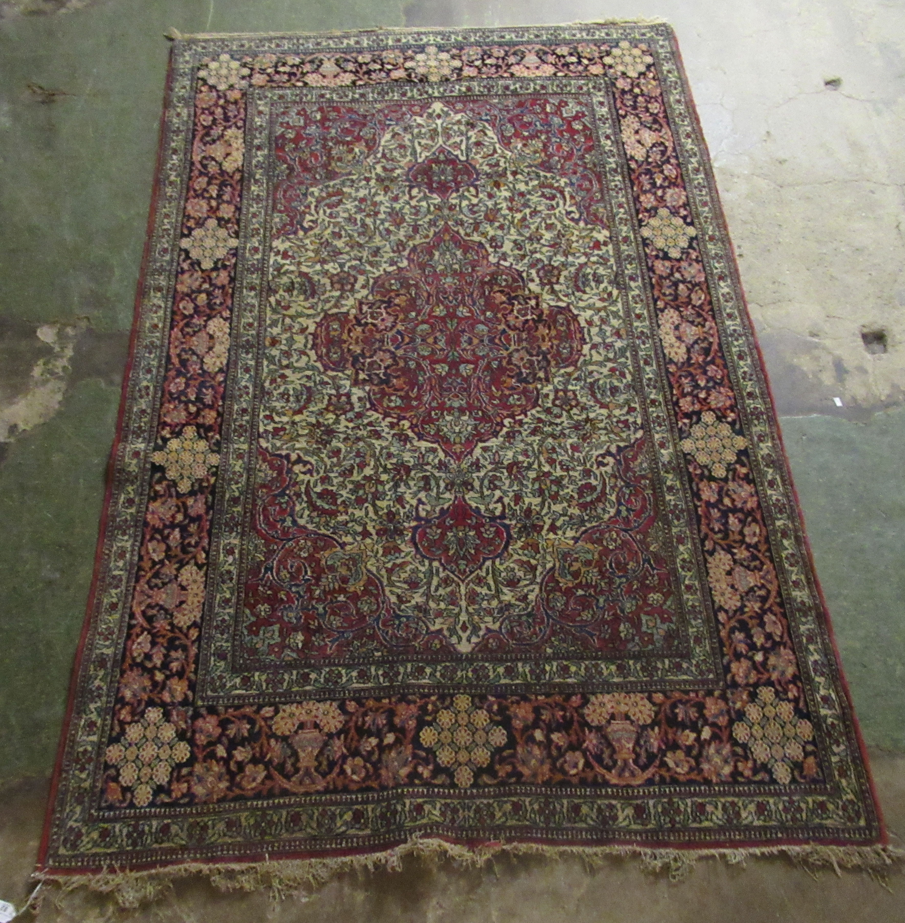 A Persian rug, decorated with a serpentine outlined medallion, bordered by stylised designs on a