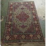 A Persian rug, decorated with a serpentine outlined medallion, bordered by stylised designs on a