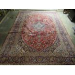 A Kashan carpet, profusely decorated in bright colours with floral designs, on a red ground  120"