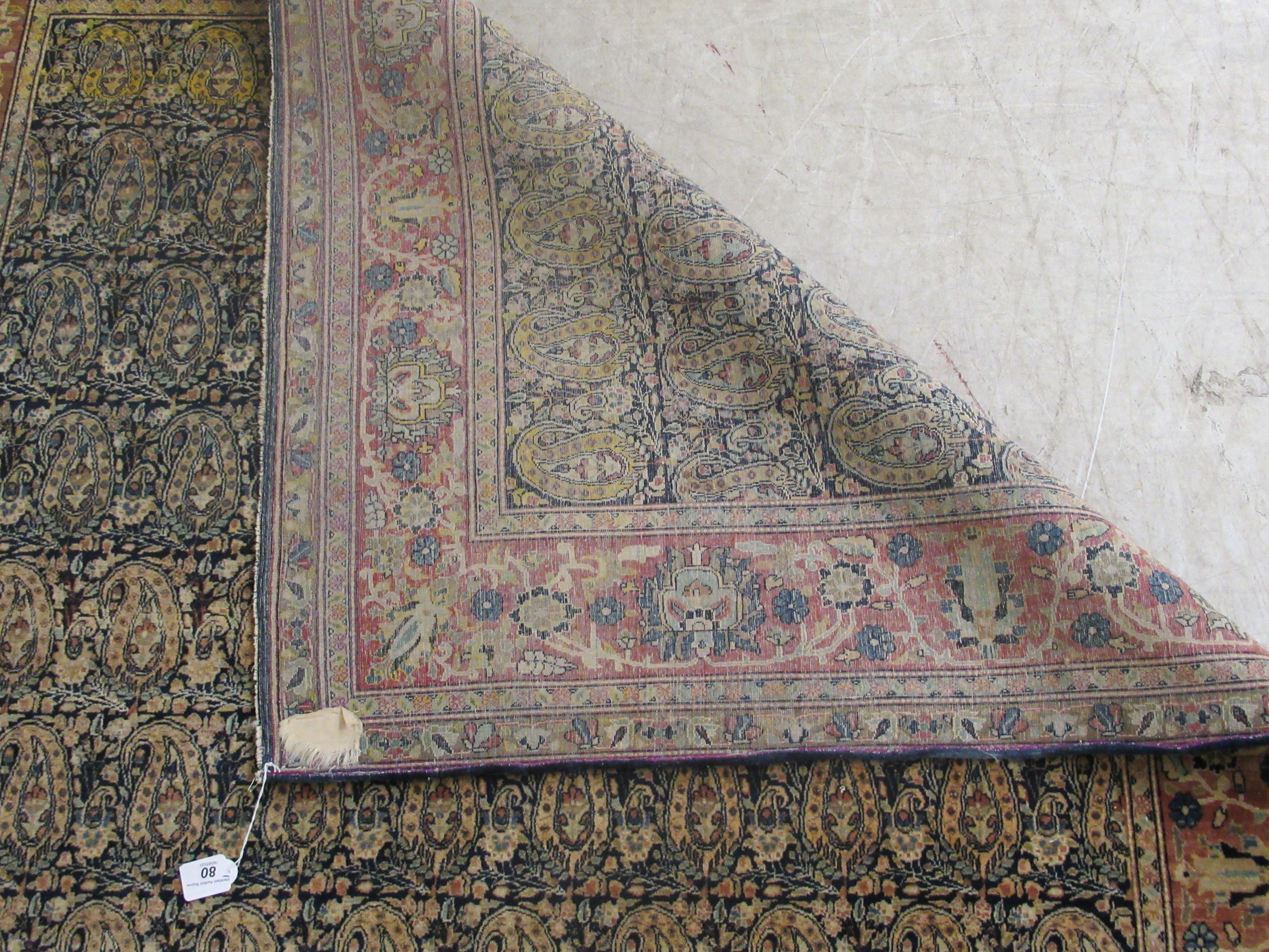 A Persian rug, decorated with repeating stylised designs, bordered by flora and foliage, on a - Image 5 of 5